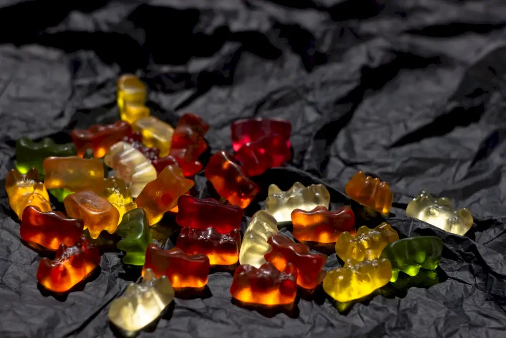 A pile of gummy bears on a black background.
