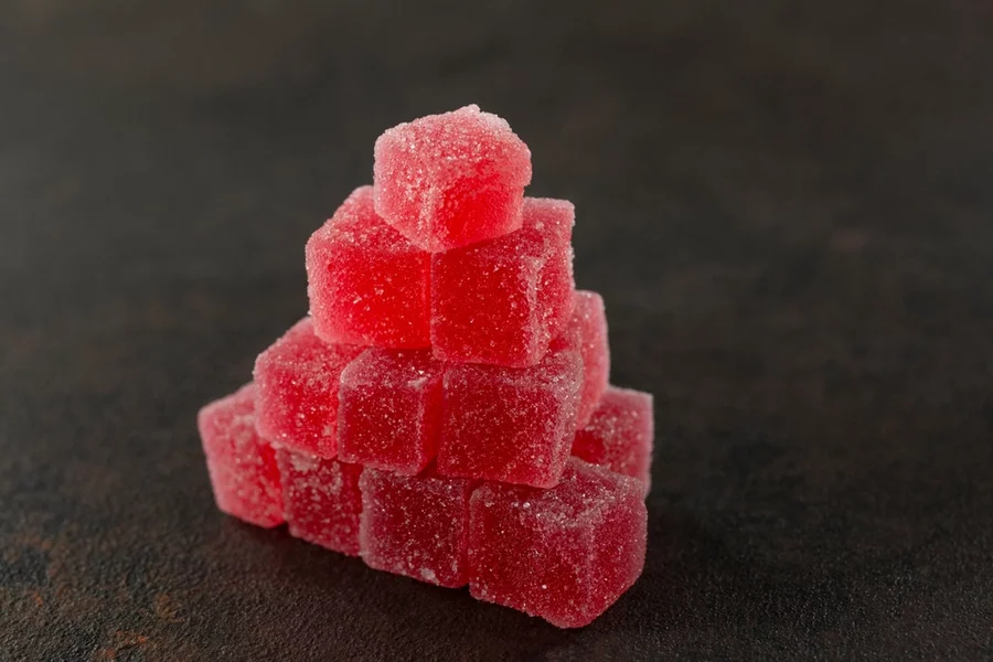 A pyramid of red edibles sits on a table.