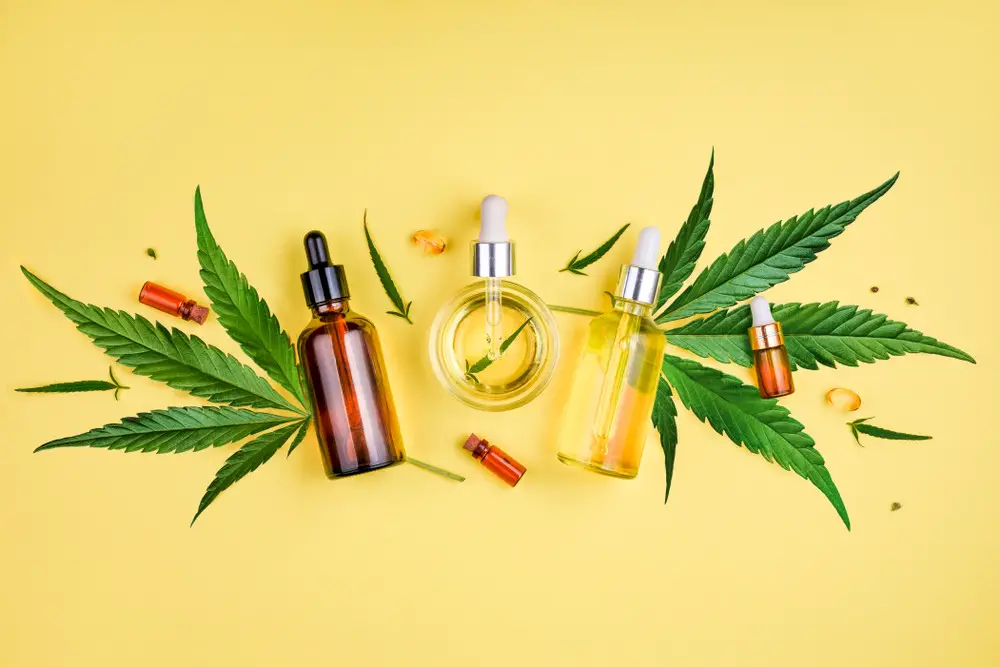 CBD oils displayed in an overhead view on a yellow background.