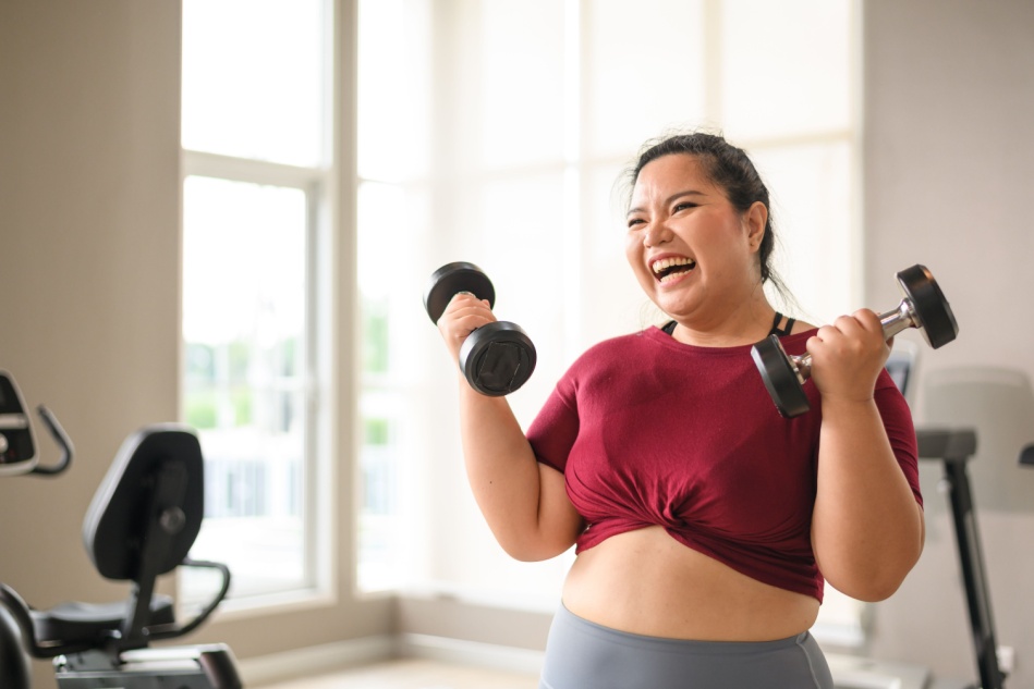 A woman works through a strength training routine in the gym. 