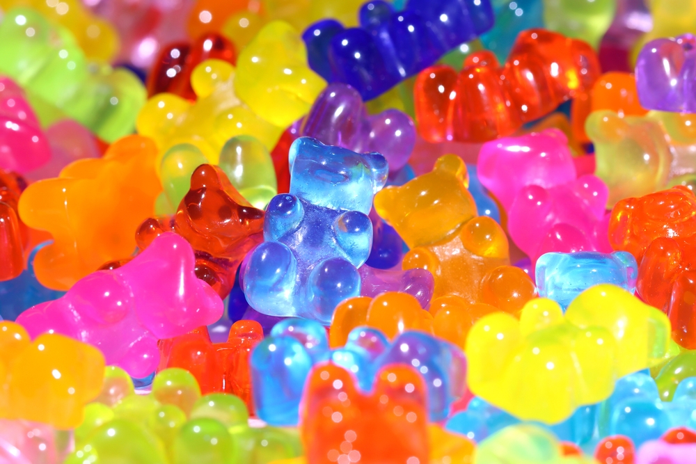 Brightly colored gummy bears sit in a pile.