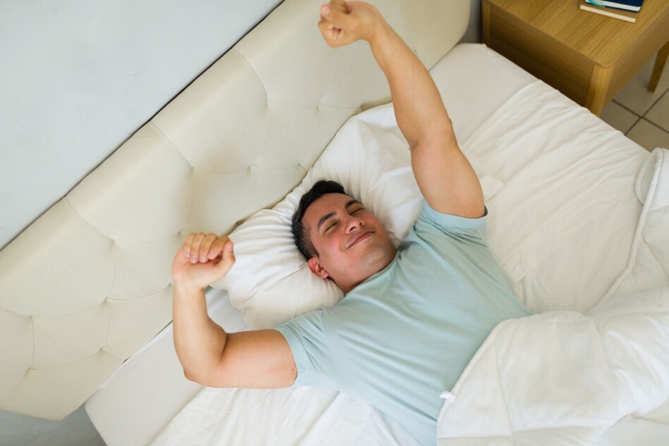 A man wakes up after a restful sleep.