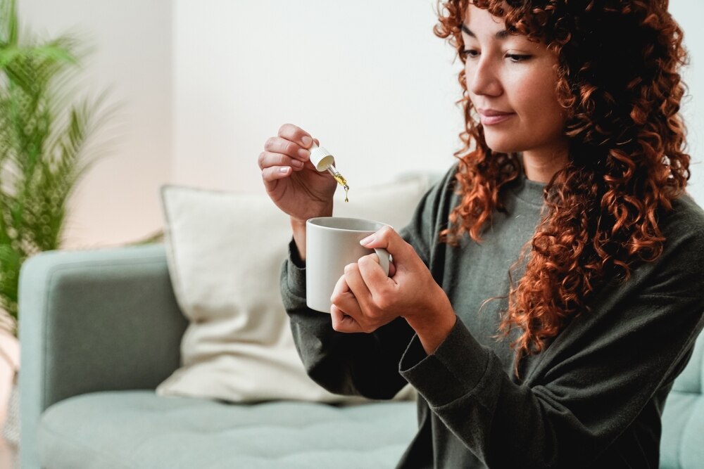 A woman adds a microdose of Delta 8 to her morning coffee. 