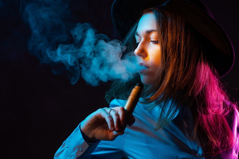 A young woman uses a low-dose nicotine vape. 