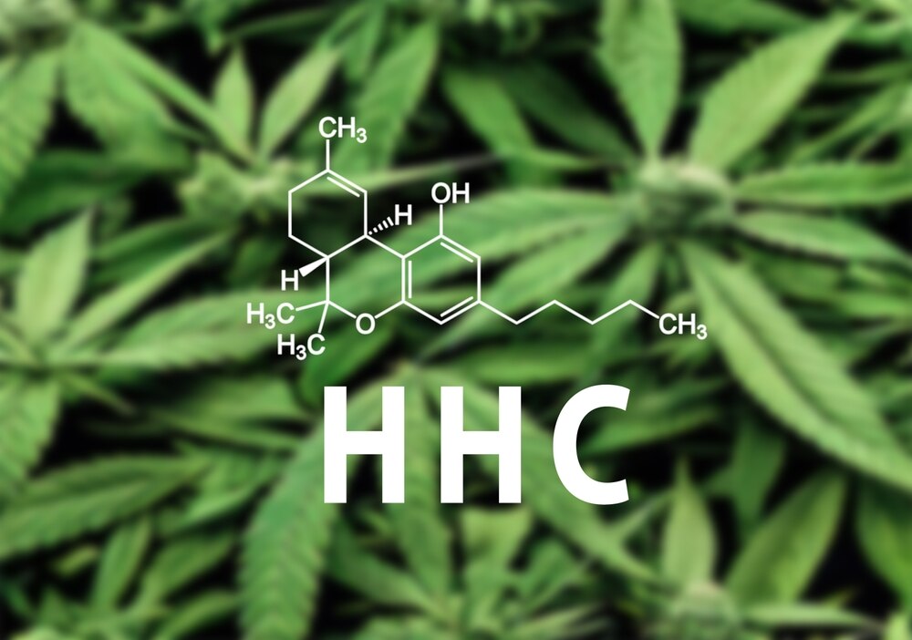 The chemical formula for HHC seen in front of a background of hemp leaves.