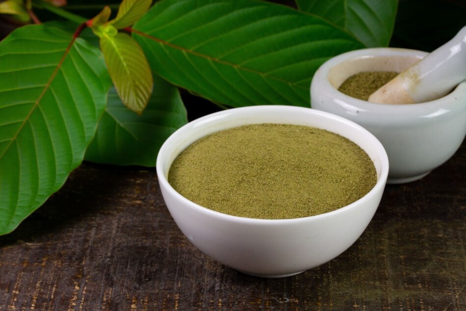 kratom powder and leaves sit on a table