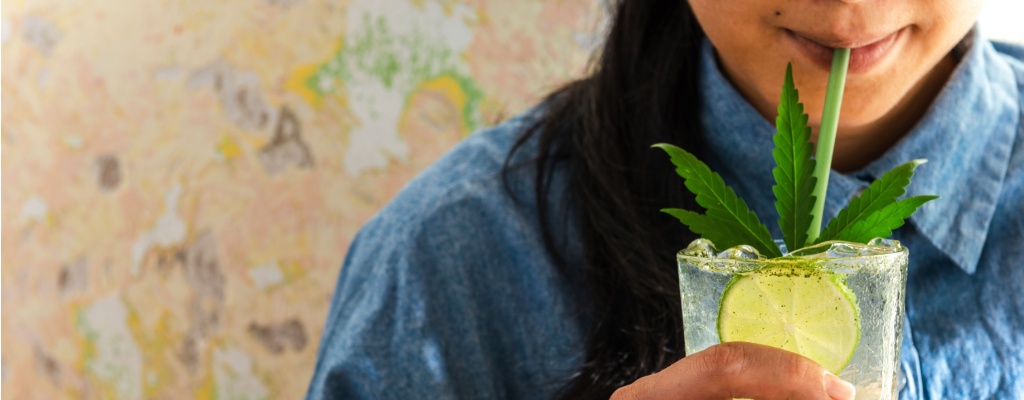 a woman enjoys a thc drink in a pint glass