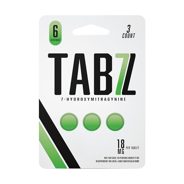Kratom tablets in a green and white packaging in front of a white background.