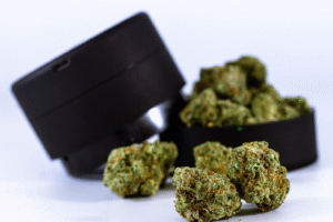 Is Delta-8 Safe? Shown by a set of hemp flowers and a flower grinder in the background.