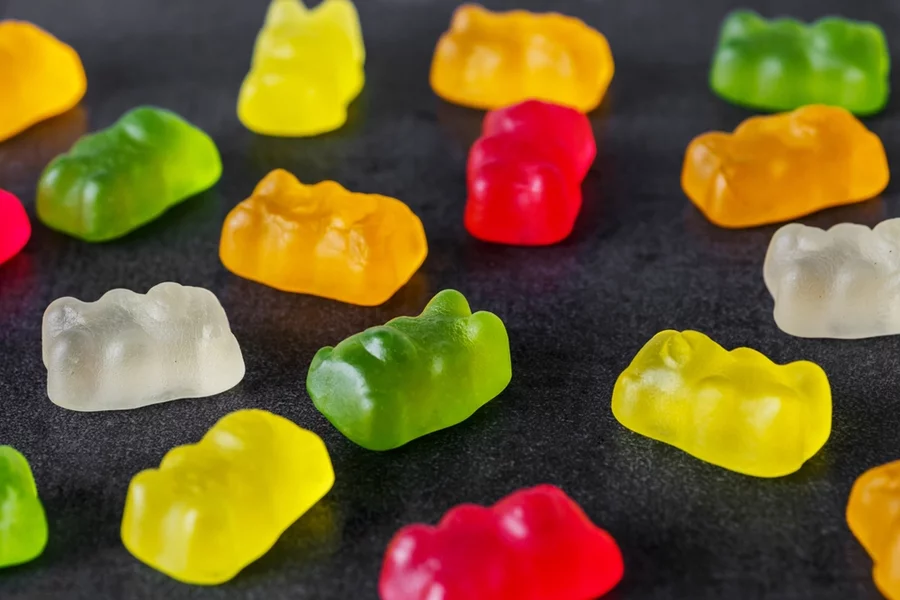 THC gummies arranged in a grid on a black table.