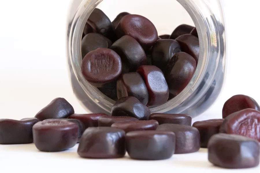 A jar of L-theanine gummies spills out onto a table.