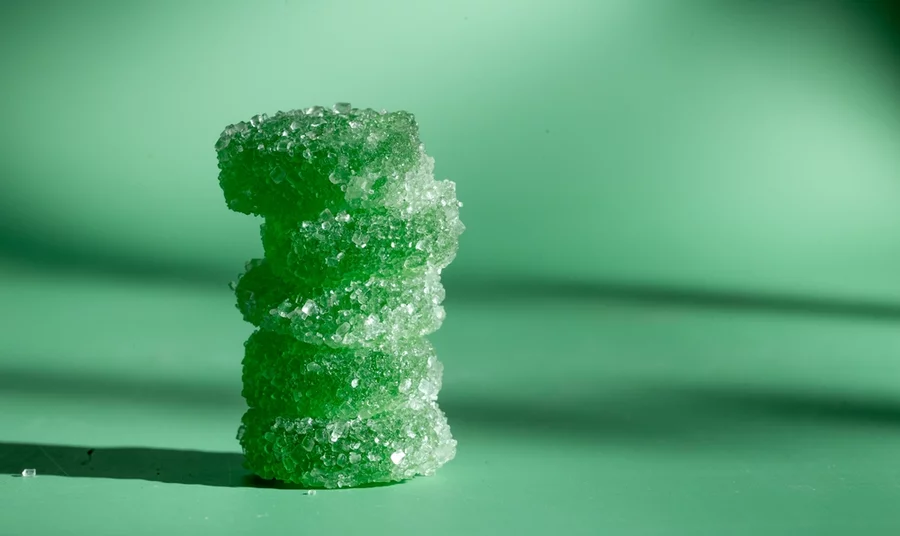 A stack of green CBD gummies on a countertop.